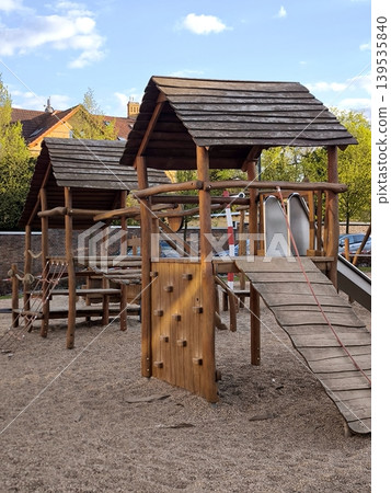 Children's wooden playground in the form of a fortress with a slide and climbing frames 139535840