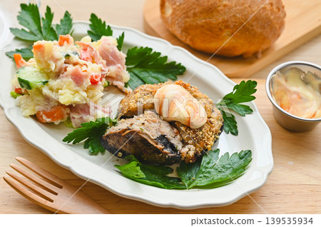 Portobello mushrooms stuffed with meat, breaded and baked, served with potato salad. 139535934