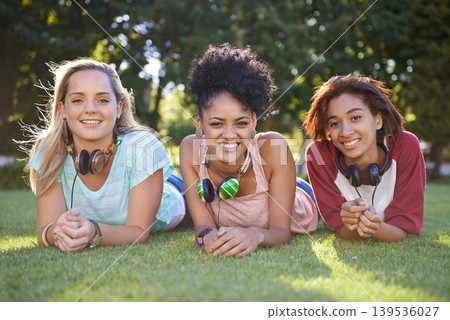 Grass, portrait or women in park at college, campus or together with community, smile or group. University, relax or happy students bond with support, headphones or diversity in education on field Grass, portrait or women in park at college, campus or together with community, smile or group. University, relax or happy students bond with support, headphones or diversity in education on field 139536027