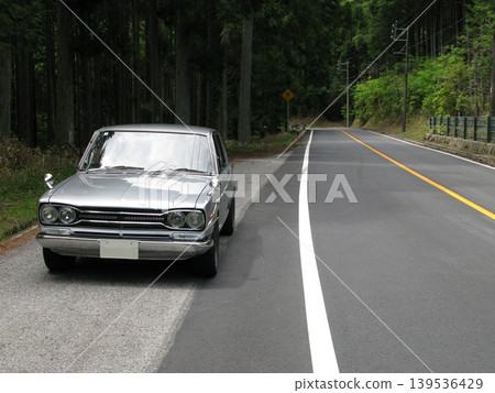 駕駛一輛老舊汽車行駛在山路上 139536429