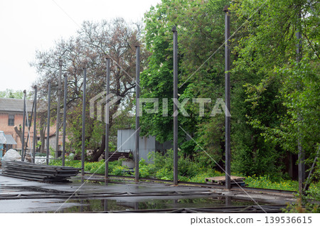Row of vertical steel pillars at an outdoor construction site for a new industrial building or warehouse frame. Row of vertical steel pillars at an outdoor construction site for a new industrial building or warehouse frame. 139536615