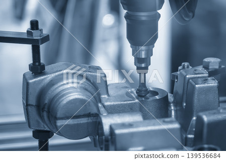 Advanced industrial robotic arm performing chamfering process on cast iron parts in a blue-toned smart factory. Advanced industrial robotic arm performing chamfering process on cast iron parts in a blue-toned smart factory. 139536684