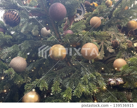 Christmas tree adorned with sparkling golden and brown ornaments for festive celebration background 139536915
