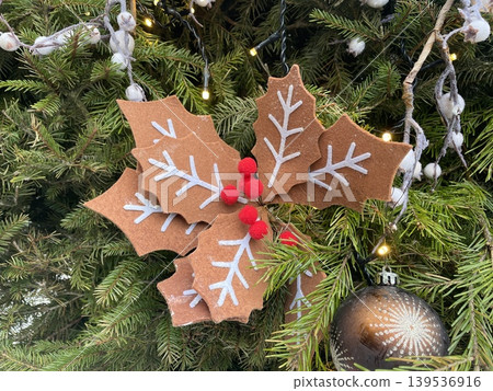 Christmas decoration with felt leaves and red berries on evergreen tree background Christmas decoration with felt leaves and red berries on evergreen tree background 139536916