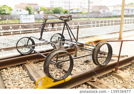 Old metal frame on railway tracks highlights unique design near urban landscape during daylight 139536977
