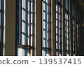 Light streams in through the wooden-framed windows of a series of modern buildings. 139537415