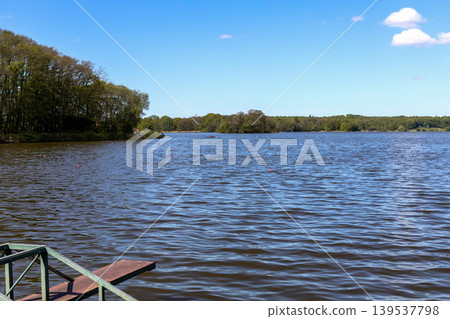 Blue lake water and peaceful nature landscape under clear sky in Denmark. Blue lake water and peaceful nature landscape under clear sky in Denmark. 139537798
