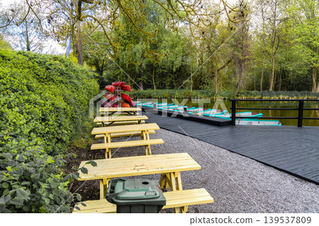 Lakeside recreation area with picnic tables and boat rental. Lakeside recreation area with picnic tables and boat rental. 139537809