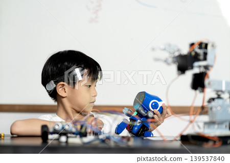 young boy having fun connecting electronic circuit board young boy having fun connecting electronic circuit board 139537840