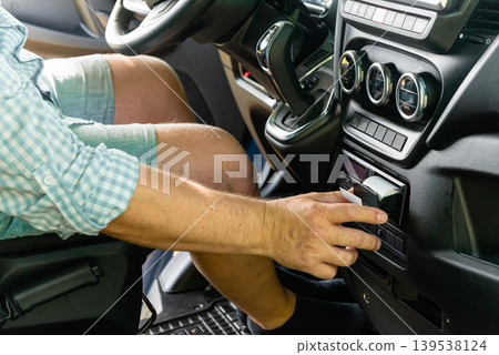 Hand inserting driver card into digital tachograph Hand inserting driver card into digital tachograph 139538124