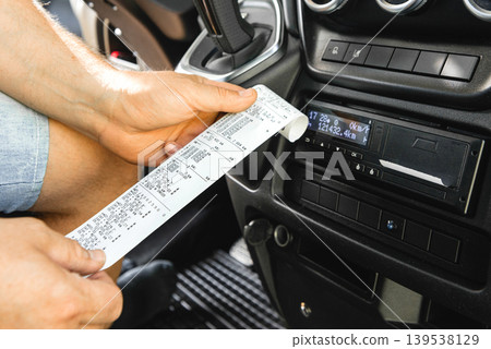 Detailed view of tachograph paper printout in hand Detailed view of tachograph paper printout in hand 139538129