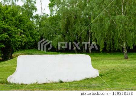 White concrete bench on green grass in park White concrete bench on green grass in park 139538158