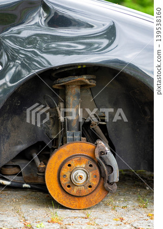 Rusty brake disc on damaged car without wheel Rusty brake disc on damaged car without wheel 139538160