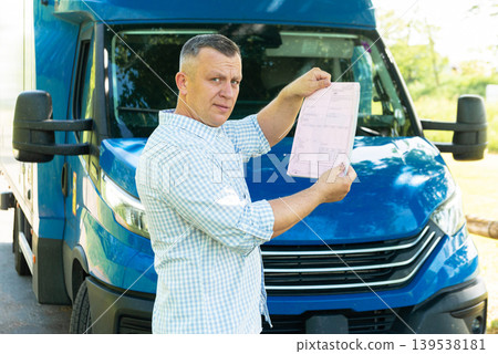 Truck driver showing delivery paper to camera Truck driver showing delivery paper to camera 139538181