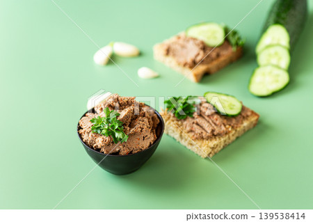 rustic meat spread with cucumber on green backdrop rustic meat spread with cucumber on green backdrop 139538414
