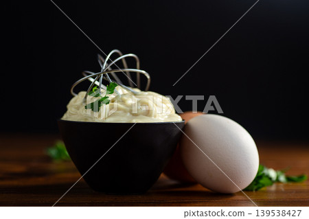 Homemade mayonnaise with herbs and eggs on a black background Homemade mayonnaise with herbs and eggs on a black background 139538427