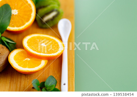 bright orange slices and kiwi on wooden cutting board bright orange slices and kiwi on wooden cutting board 139538454