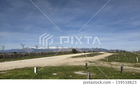 Rural dirt road and open field landscape with snowcapped mountains and blue sky for nature background and outdoor wallpaper Rural dirt road and open field landscape with snowcapped mountains and blue sky for nature background and outdoor wallpaper 139538623