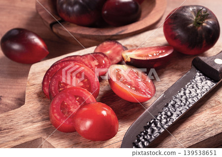 sliced tomatoes, Black Beauty variety, on a cutting board, top view,on the kitchen table, sliced tomatoes, Black Beauty variety, on a cutting board, top view,on the kitchen table, 139538651