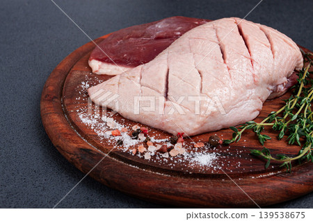 Fresh raw duck breasts, on a wooden chopping board, with herbs and spices, no people Fresh raw duck breasts, on a wooden chopping board, with herbs and spices, no people 139538675