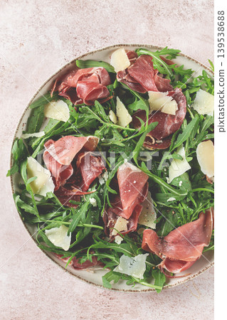 Fresh arugula salad with prosciutto and grated parmesan cheese, on a plate, homemade, no people, 139538688