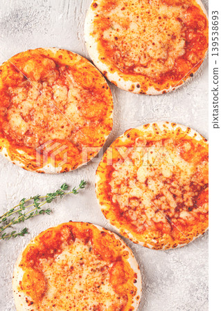 Four pizzetta Margaritas, on a light grey surface, top view, Four pizzetta Margaritas, on a light grey surface, top view, 139538693