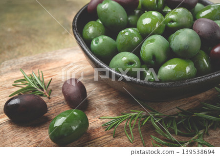 Chalkidiki olives, classic Greek green olives, in a bowl on a cutting board, top view, without people, Chalkidiki olives, classic Greek green olives, in a bowl on a cutting board, top view, without people, 139538694