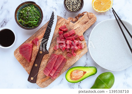 Cooking fresh tuna with ingredients on a marble countertop, ingredients for making sushi and tuna tartare Cooking fresh tuna with ingredients on a marble countertop, ingredients for making sushi and tuna tartare 139538710