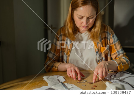Household budgeting and financial stress concept with woman checking bills at home Household budgeting and financial stress concept with woman checking bills at home 139539487