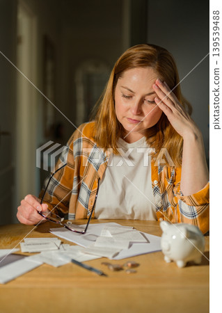Cost of living crisis concept with worried woman counting coins at home Cost of living crisis concept with worried woman counting coins at home 139539488