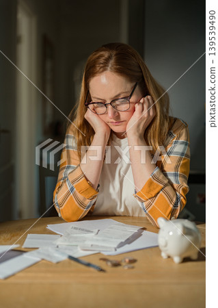 Cost of living crisis concept with worried woman counting coins at home, copy space Cost of living crisis concept with worried woman counting coins at home, copy space 139539490