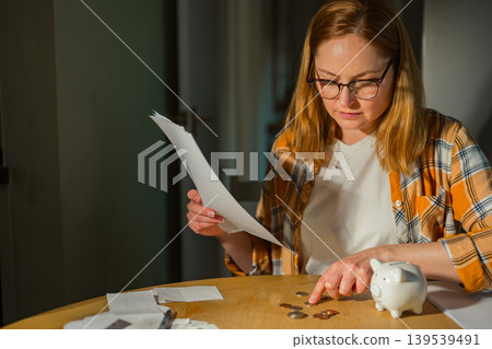 Paying bills and household budgeting concept with thoughtful woman at home, copy space Paying bills and household budgeting concept with thoughtful woman at home, copy space 139539491