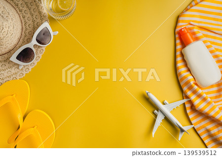Summer background. Sunglasses, beach flip-flops, sunscreen, sun hat and airplane. Yellow background with copy space. Summer background. Sunglasses, beach flip-flops, sunscreen, sun hat and airplane. Yellow background with copy space. 139539512