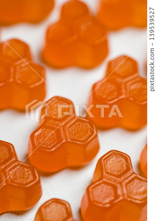 Food supplements. Orange vitamins jelly gummies on bright background Food supplements. Orange vitamins jelly gummies on bright background 139539527