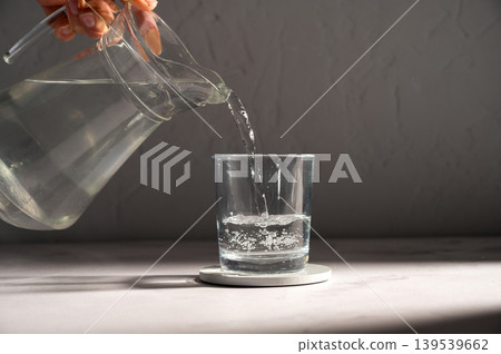 Pouring drinking water in a transparent glass Pouring drinking water in a transparent glass 139539662