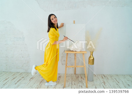 A Joyful Artist Proudly Showcasing Their Colorful Paint Brushes in a Bright and Inspiring Studio Environment 139539766
