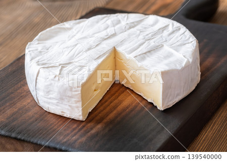 Creamy Camembert Cheese Wheel With Slice Removed On Rustic Wooden Board Display Creamy Camembert Cheese Wheel With Slice Removed On Rustic Wooden Board Display 139540000