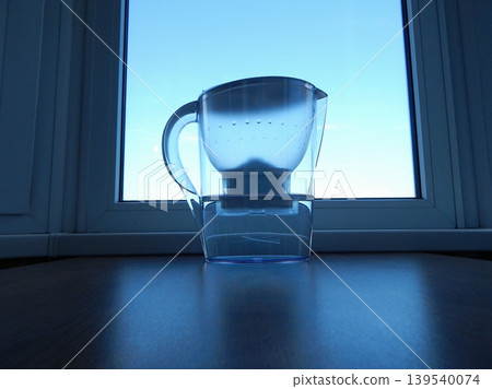 A plastic filter purifies water through a replaceable cartridge on kitchen table A plastic filter purifies water through a replaceable cartridge on kitchen table 139540074