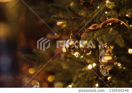 Close-up of a beautifully decorated Christmas tree with golden ornaments and twinkling lights, creating a festive atmosphere during the holiday season Close-up of a beautifully decorated Christmas tree with golden ornaments and twinkling lights, creating a festive atmosphere during the holiday season 139540246