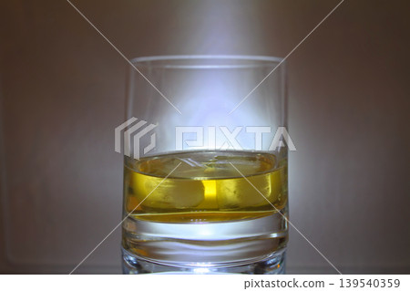 Ice cubes melts in a single glass of whiskey detailed Ice cubes melts in a single glass of whiskey detailed 139540359