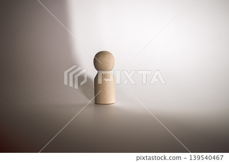 Wooden figurine standing alone on a smooth surface with soft shadows and a gradient background, emphasizing its simple design and natural texture Wooden figurine standing alone on a smooth surface with soft shadows and a gradient background, emphasizing its simple design and natural texture 139540467
