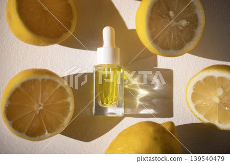 Glass dropper bottle filled with yellow oil surrounded by fresh lemon halves and whole lemons on a light background, showcasing natural skincare ingredients Glass dropper bottle filled with yellow oil surrounded by fresh lemon halves and whole lemons on a light background, showcasing natural skincare ingredients 139540479