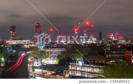 Nighttime London Skyline with Construction Cranes Urban Lights and Modern City Development Nighttime London Skyline with Construction Cranes Urban Lights and Modern City Development 139540551