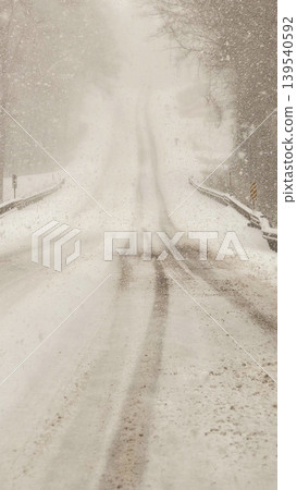 Heavy Snowfall on Curved Road with Low Visibility During Winter Storm Driving Conditions Heavy Snowfall on Curved Road with Low Visibility During Winter Storm Driving Conditions 139540592