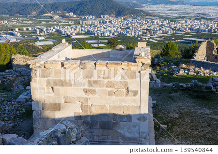 Ancient stone tomb overlooking city and greenhouse covered valley 139540844