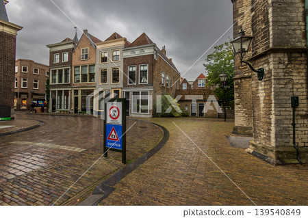 Dordrecht, Zuid-Holland provincie, Netherlands - 09.06.2025: Historic Dutch street with traditional brick houses in Dordrecht, Netherlands. Cobblestone road and traffic control signs under a moody sky Dordrecht, Zuid-Holland provincie, Netherlands - 09.06.2025: Historic Dutch street with traditional brick houses in Dordrecht, Netherlands. Cobblestone road and traffic control signs under a moody sky 139540849