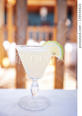 Refreshing cocktail served in a crystal glass with a lime wedge, showcasing vibrant colors and textures, perfect for summer gatherings and celebrations Refreshing cocktail served in a crystal glass with a lime wedge, showcasing vibrant colors and textures, perfect for summer gatherings and celebrations 139540928