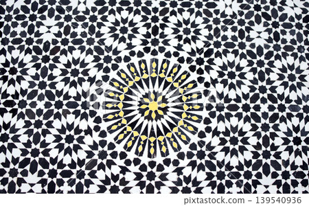 Intricate geometric pattern featuring black, white, and yellow tiles arranged in a mesmerizing design, showcasing traditional craftsmanship and artistic expression in decorative art 139540936
