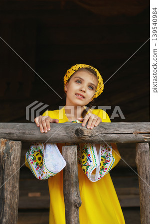 Young girl in traditional Folk-Style Dress and in crocheted yellow scarf Young girl in traditional Folk-Style Dress and in crocheted yellow scarf 139540984