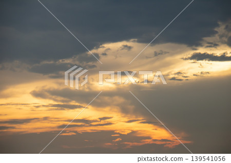 Warm sunset light breaks through layered clouds, creating a dramatic sky with soft golden tones and moody atmosphere, perfect for backgrounds, nature themes, and peaceful evening concepts. Warm sunset light breaks through layered clouds, creating a dramatic sky with soft golden tones and moody atmosphere, perfect for backgrounds, nature themes, and peaceful evening concepts. 139541056
